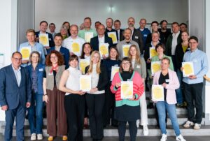 Teilnehmende bei der Gründung des Biodiversitätsbündnisses Thüringen halten ihre Gründungsurkunden in den Händen.