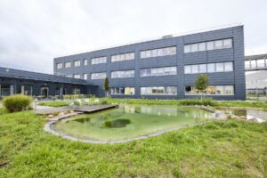Naturnah gestalteter Teich mit Grünflächen vor dem L’Oréal-Logistikzentrum Muggensturm.